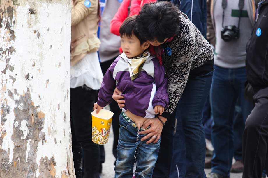 bambino fa la pipì per strada in Cina